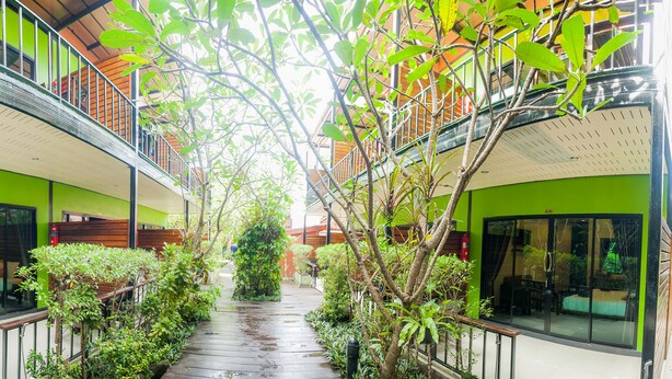 A corridor with glass walls, a wooden bench, and greenery. - Leelawadee Lipe Resort (Koh Lipe)