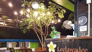 A reception desk with a sign reading "Leelawadee Lipe Resort," a plant, and a clock. - Leelawadee Lipe Resort (Koh Lipe)