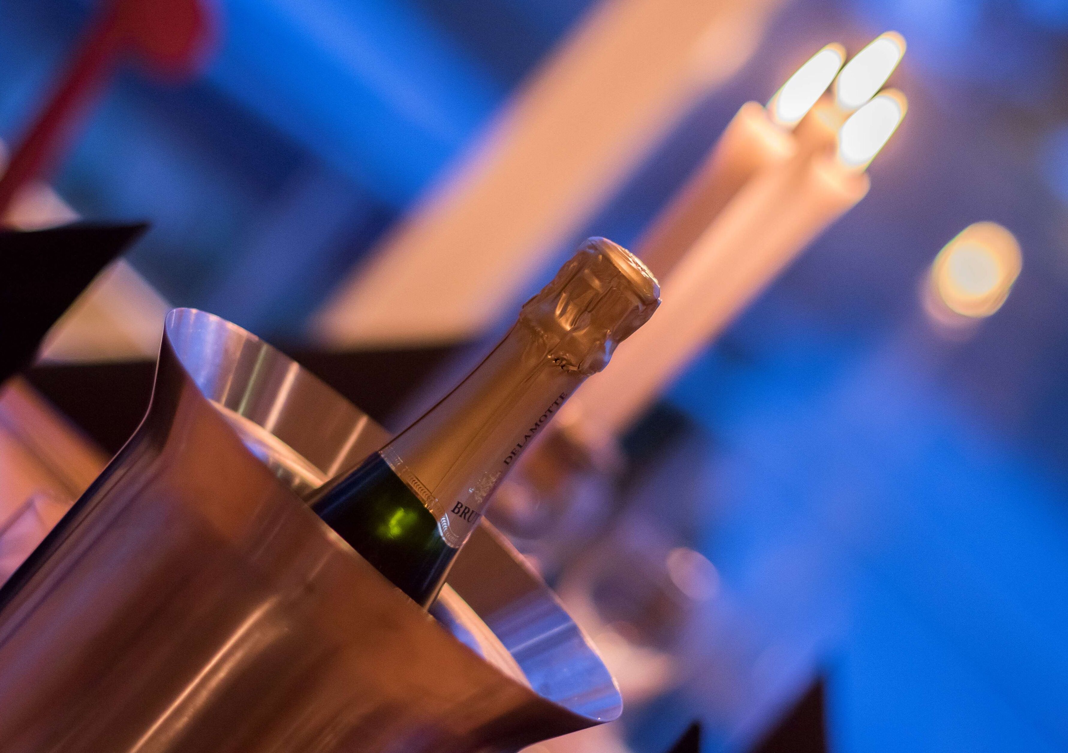 A champagne bottle in a metallic holder with a blurred background.