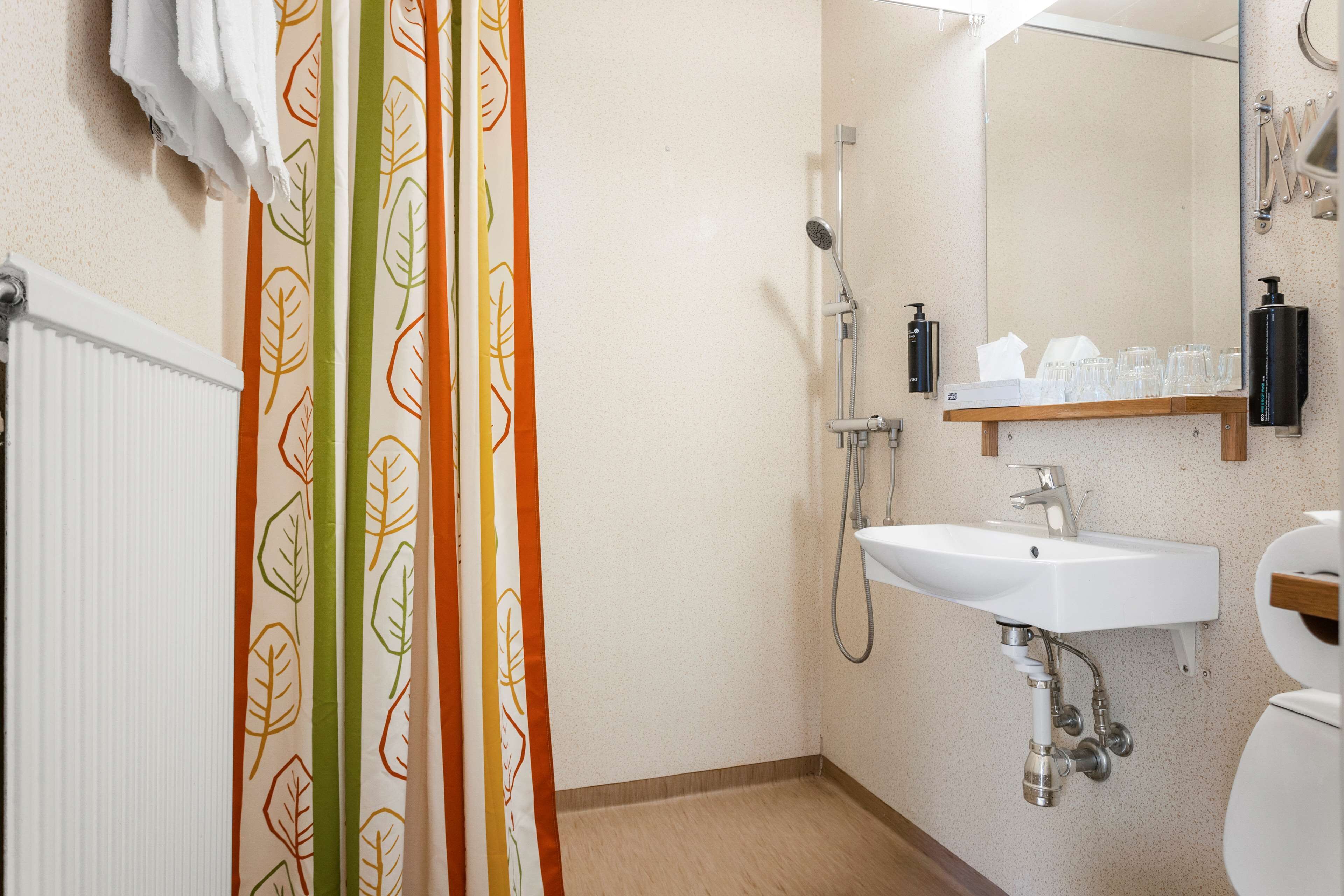 A bathroom with a shower, sink, and toilet.