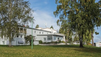 Un bâtiment à deux étages, doté d’un toit plat, de grandes fenêtres et d’une antenne parabolique bien visible.
