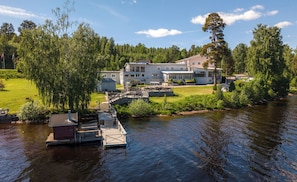 A lakeside property with a dock, a large house, and surrounding greenery. - Hotell Frykenstrand, Sure Hotel Collection by Best Western (Sunne)