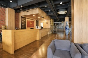 A reception area with a wooden counter, a reception desk, and a blue sofa.