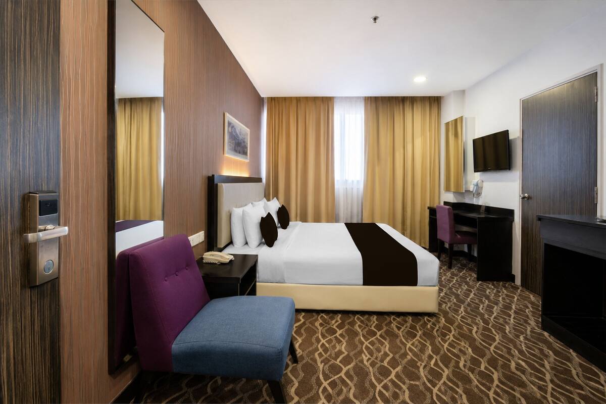 Une chambre d’hôtel équipée d’un lit, d’un bureau, d’une chaise, d’une télévision et d’une cheminée.