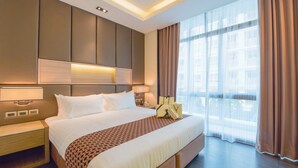 A modern hotel room with a large bed, a nightstand, a bedside table, and a large window with curtains. - Qiss Residence by Bliston (Bangkok)