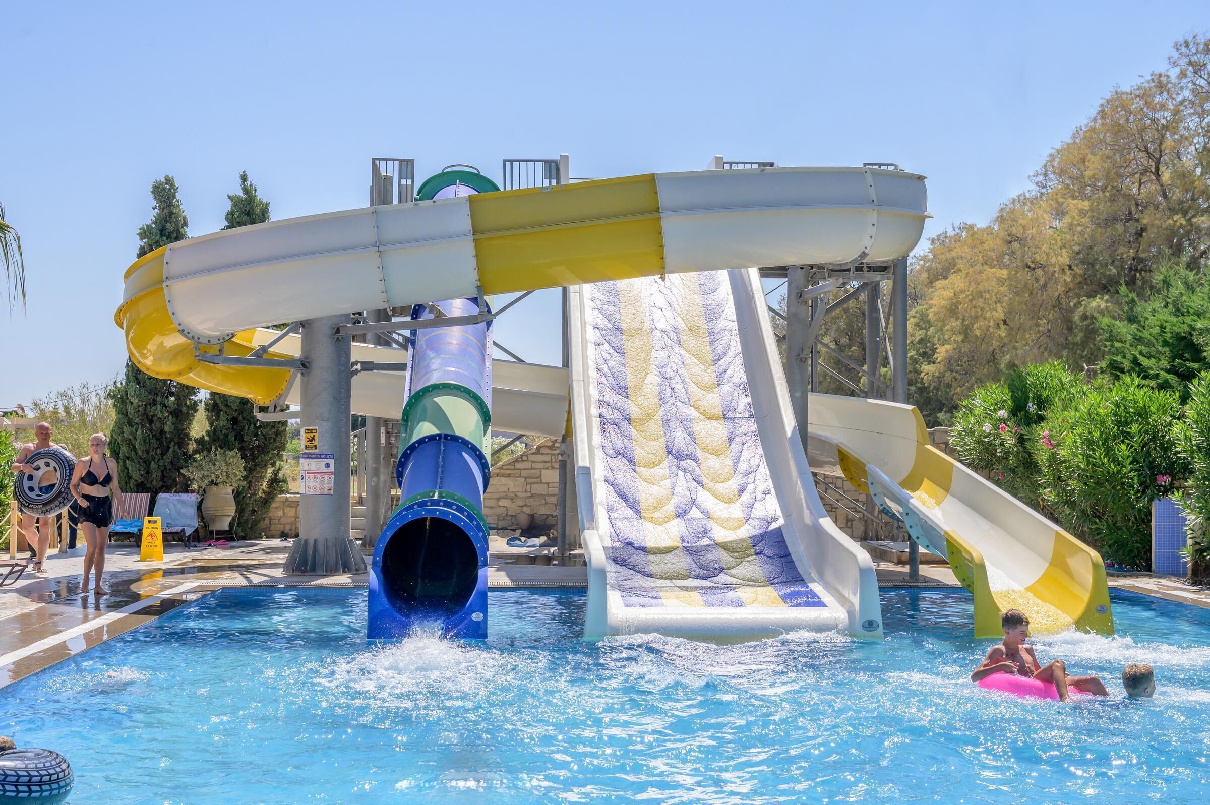 A water park with a large water slide, a pool, and a lifeguard tower.