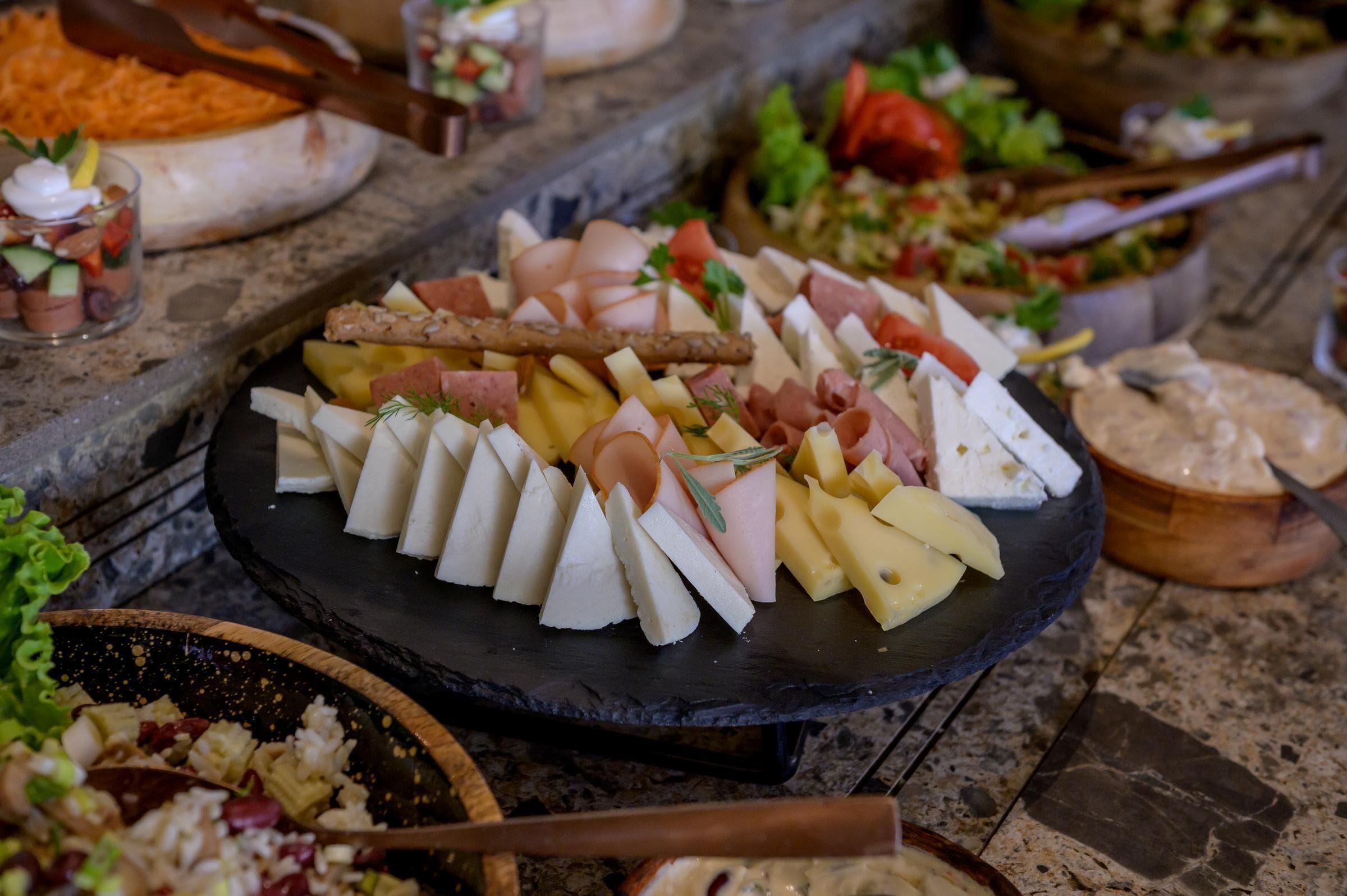A charcuterie board with various cheeses, meats, and fruits.