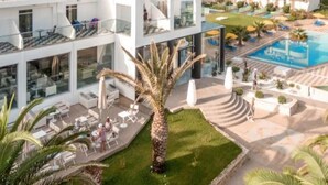 A modern hotel with a rooftop pool, outdoor seating, and a view of the surrounding landscape. - Zeus Hotels YDORIA RESORT - All Inclusive (Rethymno)