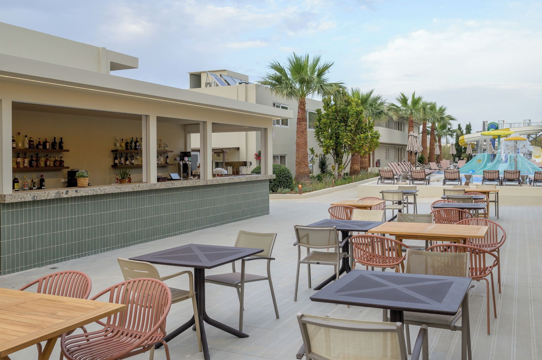 An outdoor bar area with seating and a water slide.