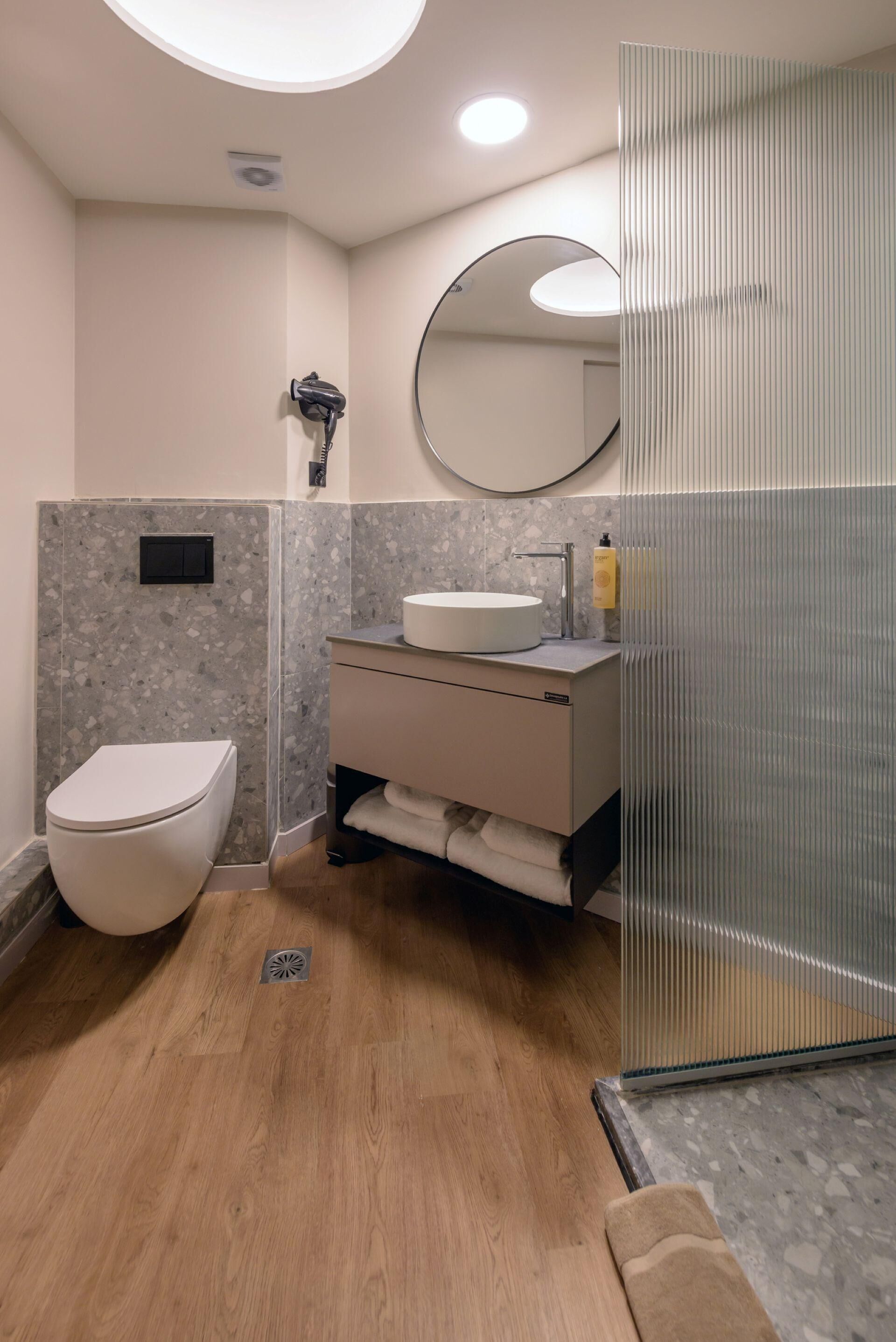 A modern bathroom with a toilet, sink, and shower area.