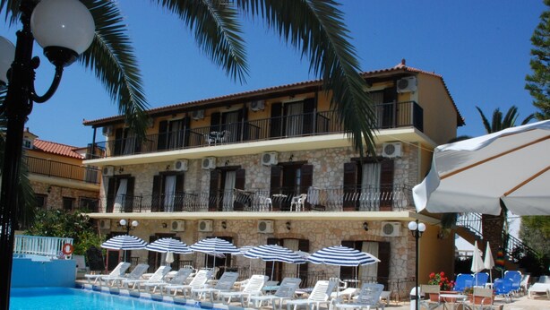 Un hôtel doté d’une piscine, de nombreuses chaises longues et de parasols.