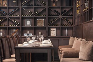 A dining area with a table set for four, surrounded by wooden chairs. - Royal Park Hotel and Apartments (Bansko)