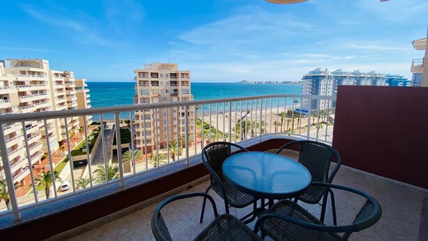 A balcony with a view of the sea and buildings. - Las Gondolas Apartments (San Javier)