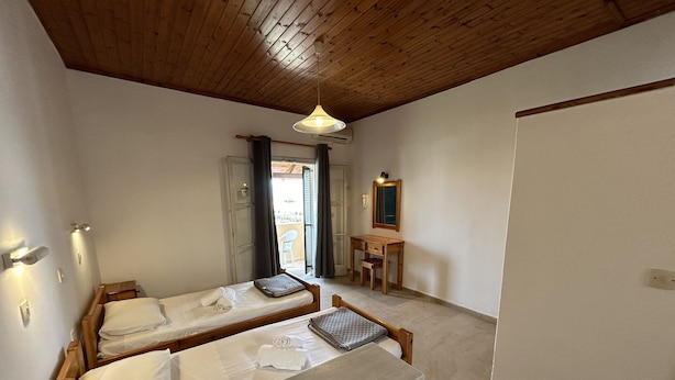 A small, cozy room with two wooden beds, a small desk, and a mirror. - Kavos Panorama Complex (Corfu)