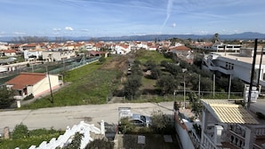A residential area with houses, a fenced sports field, and a clear sky. - Kavos Panorama Complex (Corfu)