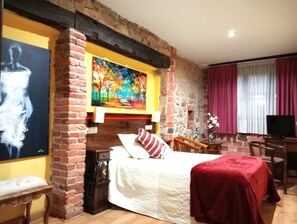 Ein Zimmer mit Bett, Schreibtisch, Stuhl, Fernseher und einem Bild an der Wand.