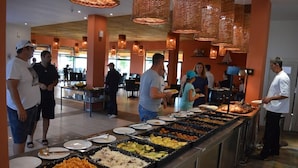 A buffet area with various food options and people dining.