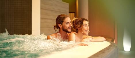 Una pareja en un jacuzzi con burbujas y agua.