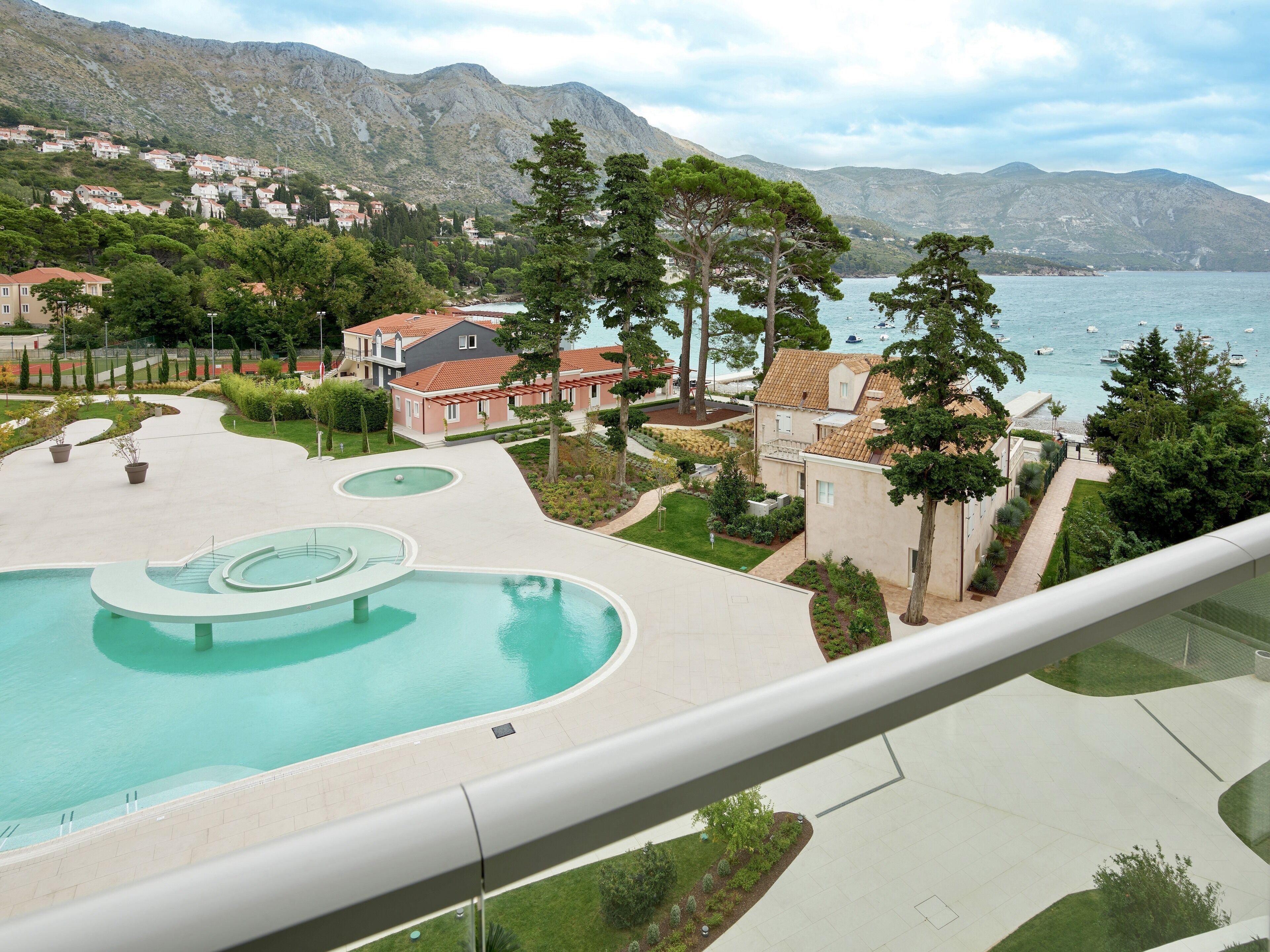 Zona residencial con piscina, casas y montañas al fondo.