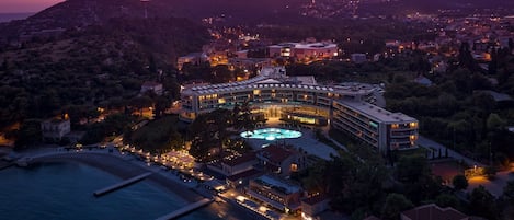 Vista aérea de un hotel costero con piscina, varias edificaciones y una zona de playa.