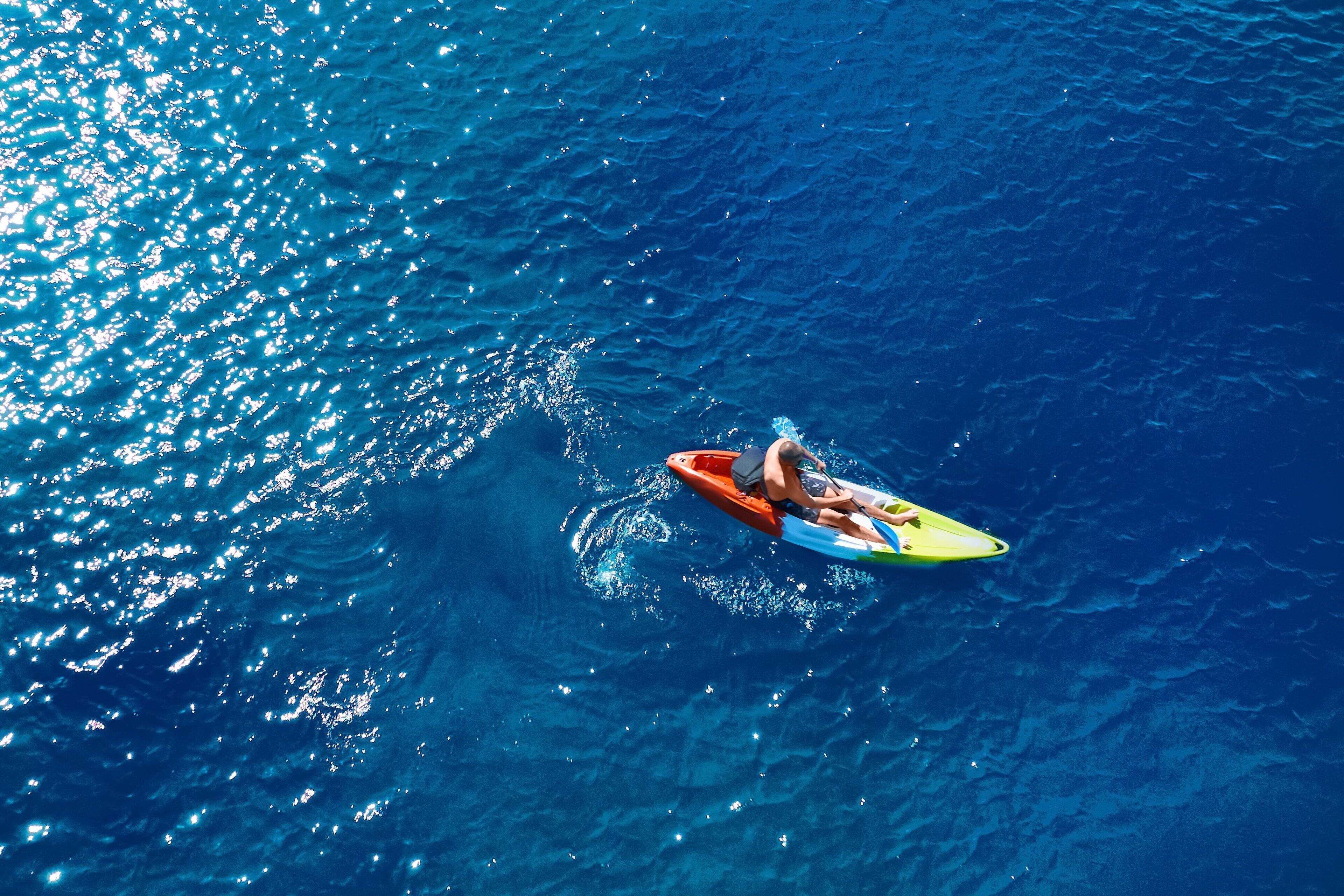 A person on a yellow kayak in a body of water.