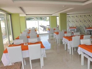A dining area with tables set for service, chairs, and a patterned wall. - Harmony Side Hotel (SIDE / MANAVGAT)