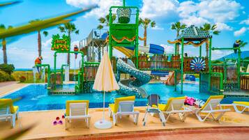 A water park with slides, a pool, and lounge chairs.