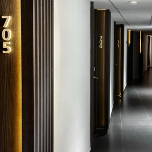Corredor de hotel com portas numeradas 705 e 706.