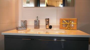 Un tocador de baño con espejo, lavabo y un armario debajo.