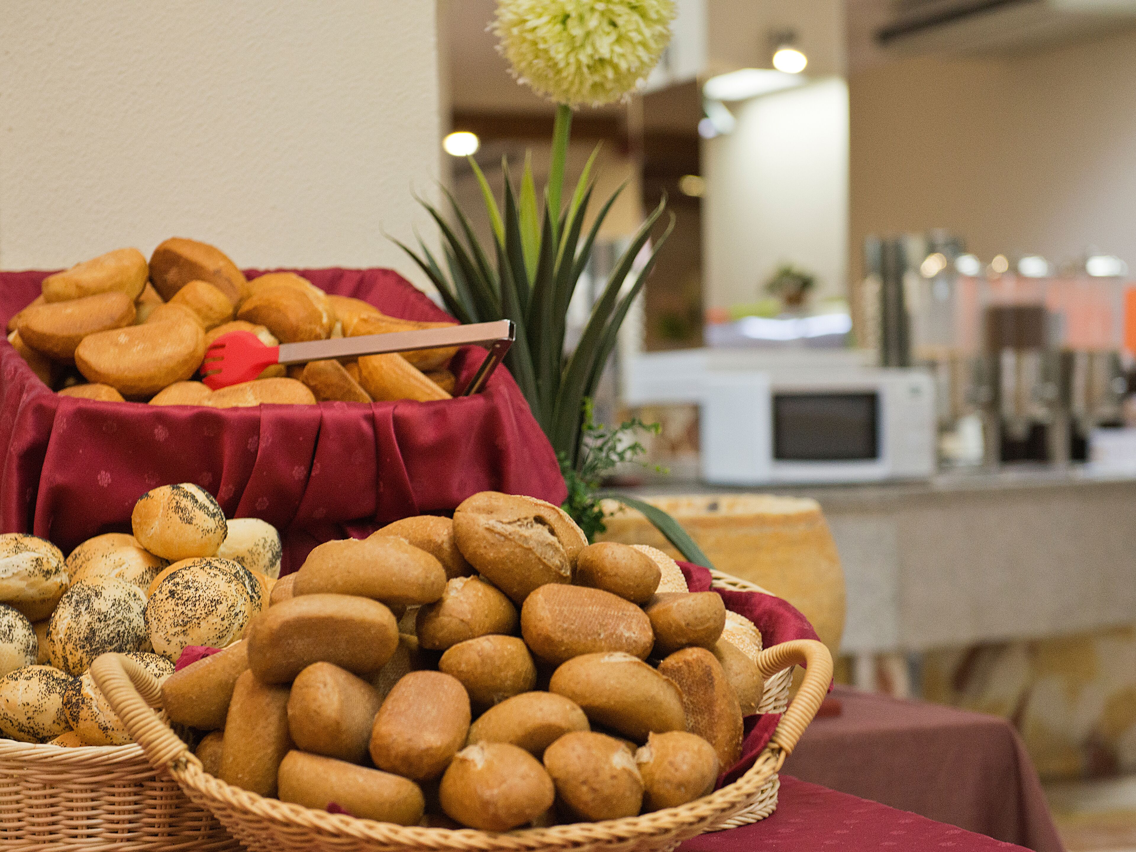 Una mesa de buffet con panes y pasteles varios.