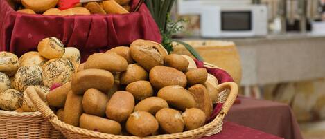 Una mesa de buffet con panes y pasteles varios.