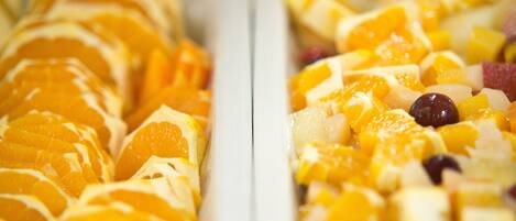 Una bandeja de frutas con mandarinas en rodajas y otras frutas.