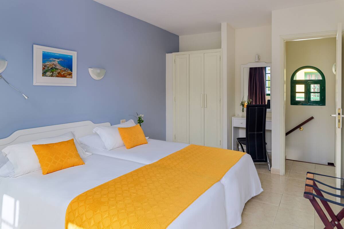 Ein Hotelzimmer mit einem großen Bett, einem Schreibtisch und Blick ins Freie.