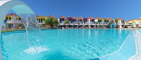 Una piscina al aire libre, sombrillas, tumbonas