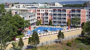 Un hôtel doté de nombreux balcons, d’une piscine et offrant une vue sur les environs.