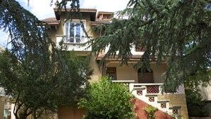 A two-story house with a balcony, a stone facade, and a small garden area. - Hôtel le Lyon Bron (Bron)