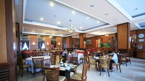 A spacious restaurant with multiple dining areas, wooden furniture, and a chandelier. - Hotel Pacific Balikpapan (Balikpapan)