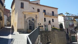 A building with an arched entrance, a balcony, and a sign reading "B&B". - Palazzo Madeo - Residenza d'Epoca (Crosia)