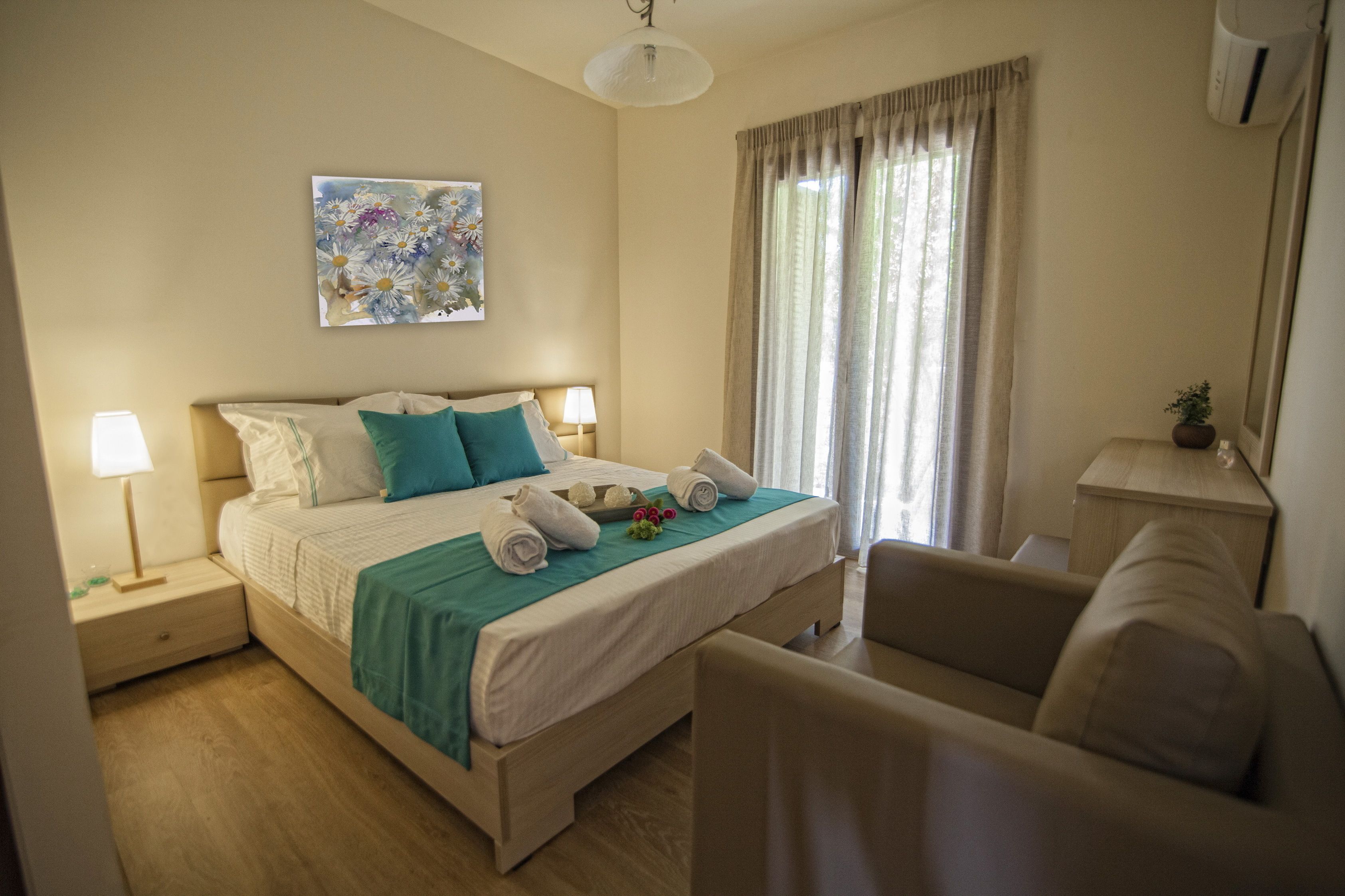 A neatly arranged bedroom with a bed, bedside tables, a chair, and a window with curtains.