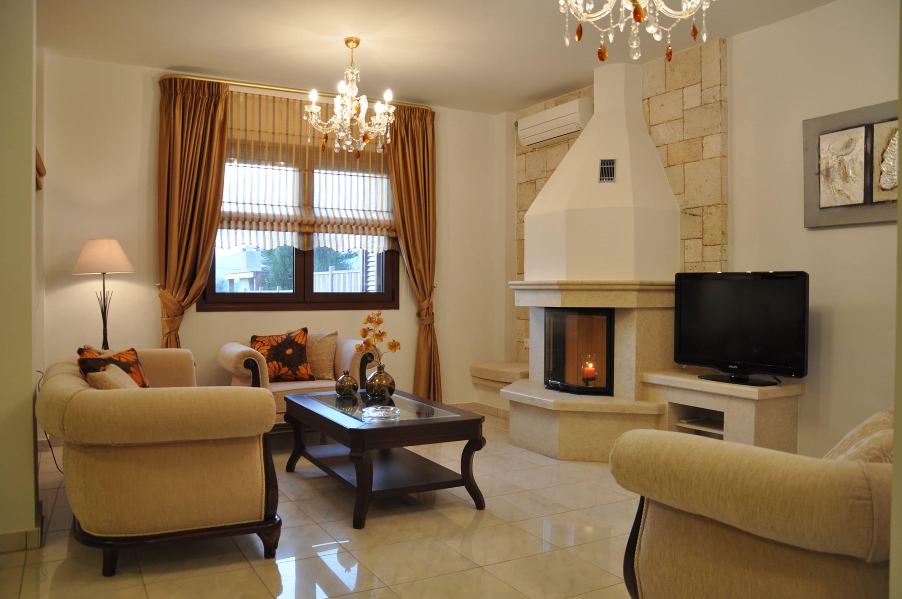 A living room with a fireplace, sofa, coffee table, and television.