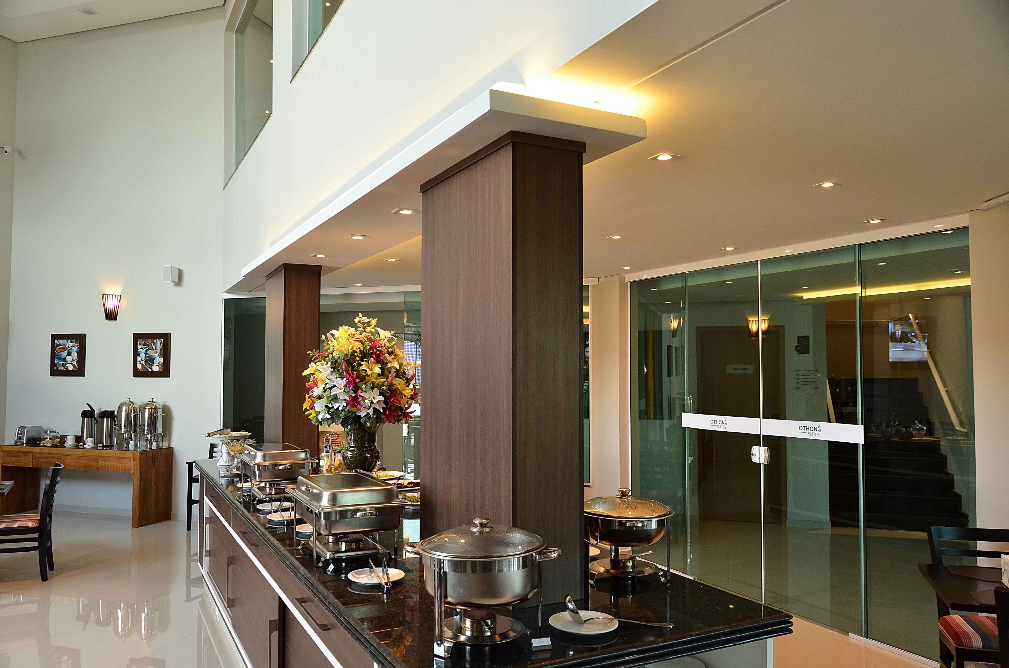 Un hall d’hôtel moderne avec un buffet, un escalier et un mur en verre.