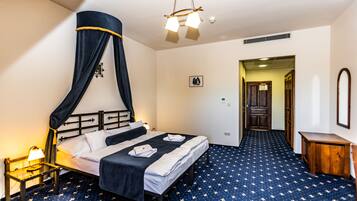 A room with a bed, a nightstand, a lamp, a ceiling light, and a patterned carpet.