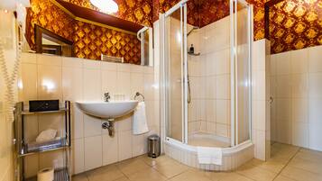 A bathroom with a sink, mirror, and shower.