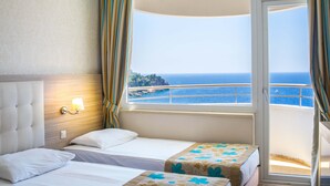 A hotel room with two beds, a large window with a view of the sea, and a balcony. - Cender Hotel (Antalya)
