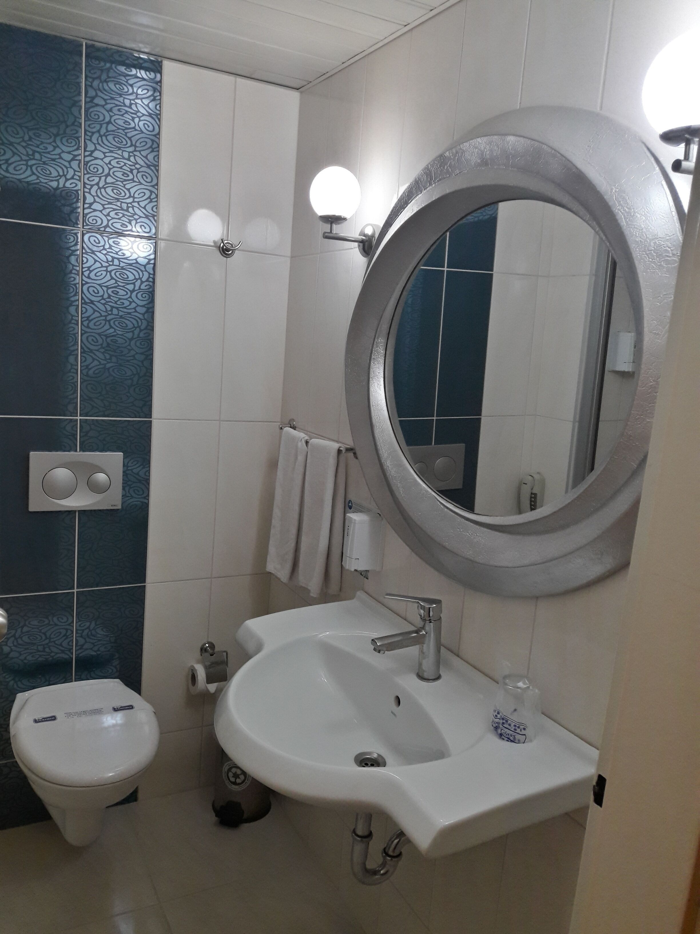 Un baño con inodoro, lavabo y espejo.