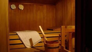 Un sauna de madera con bancos y un cubo de madera.