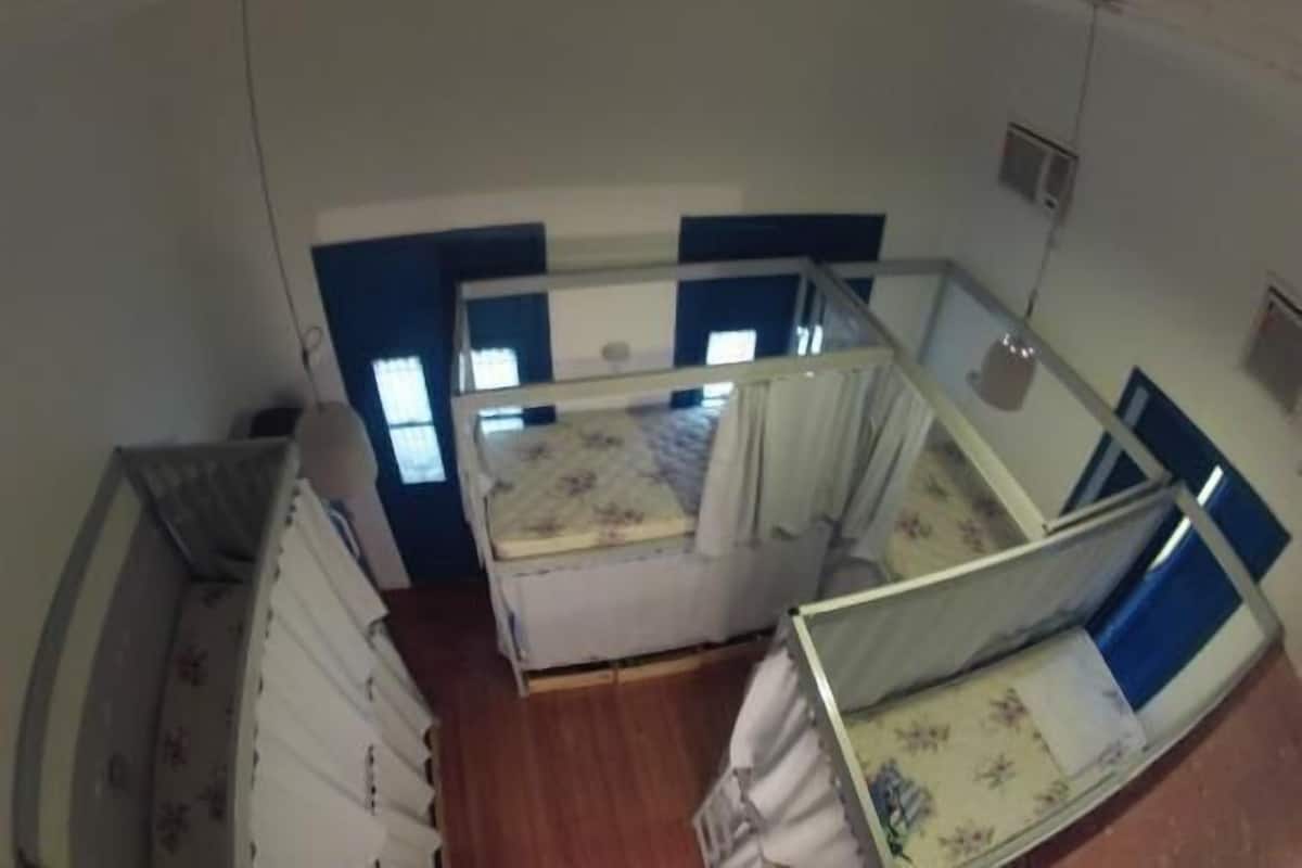Quarto com duas camas, uma janela e uma porta.