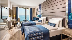 A modern hotel room with two beds, a desk, and a view of the sea. - Crowne Plaza Istanbul Florya by IHG (Istanbul)