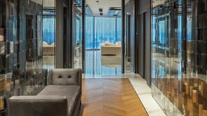 A modern hotel lobby with a central seating area, reflective glass walls, and a view of the city through large windows. - Crowne Plaza Istanbul Florya by IHG (Istanbul)