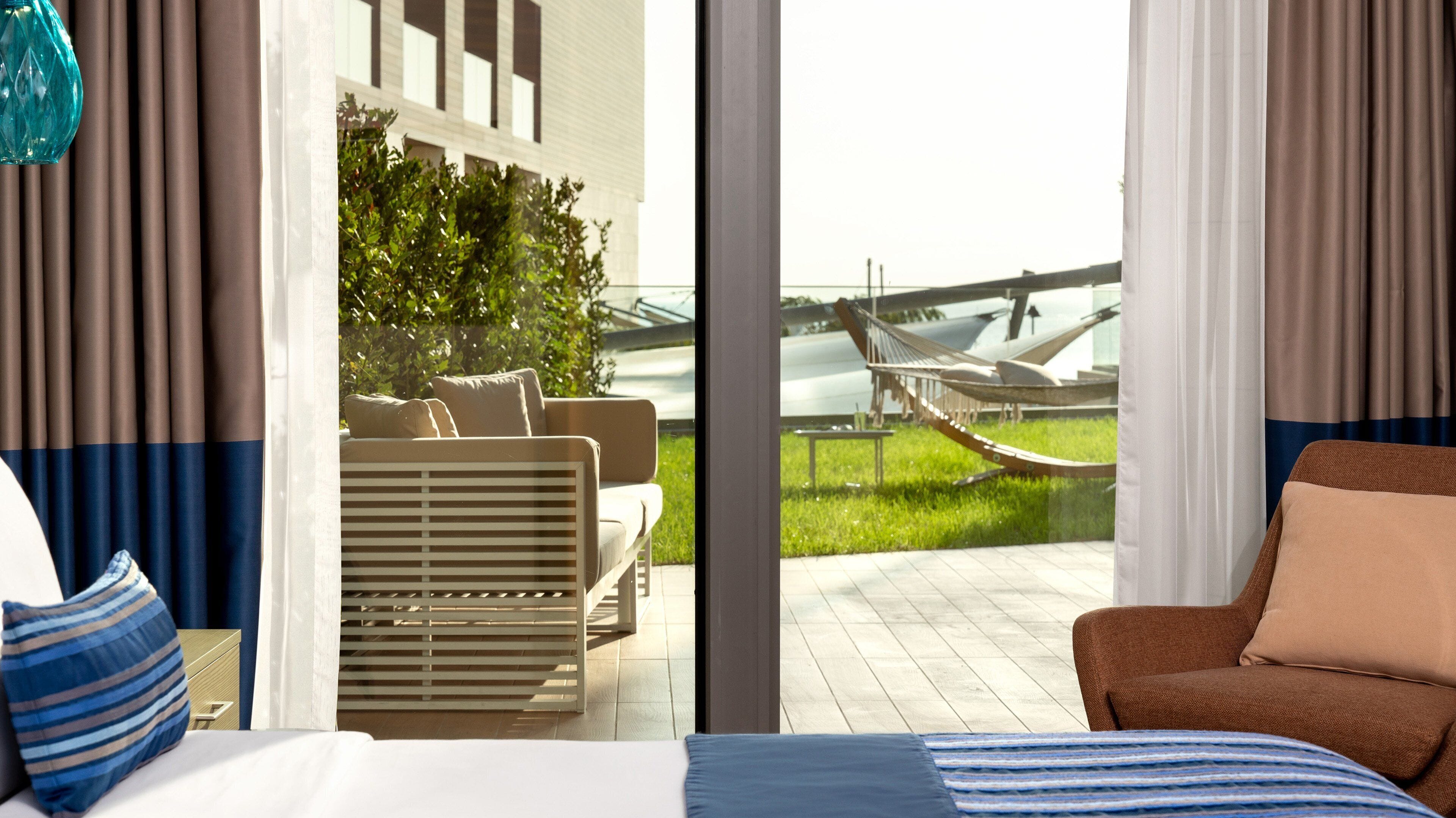Ein Hotelzimmer mit einem großen Bett, einer Couch und Blick auf ein Flugzeug vor dem Fenster.